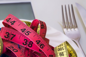 scales and metric tapes with steel cutlery. diet and slimming concept