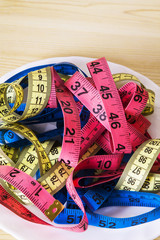 plate with colored tape measure. diet and slimming concept
