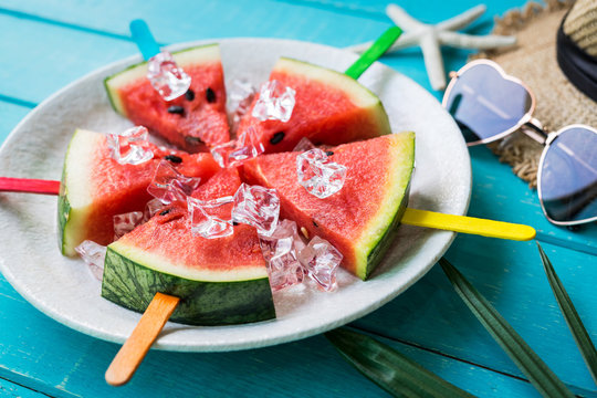 Watermelon slice popsicles with colorful stick on wooden background, Summer fruits