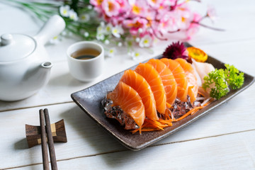 Salmon sashimi slice fresh serve on ice with tea, Japanese style