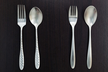 stainless steel spoon on black wood background.