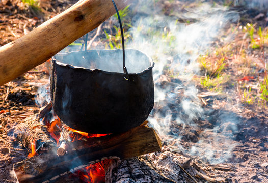 cauldron in steam and smoke on open fire