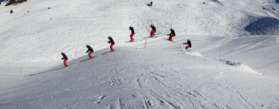 Young, female skier, jumping in the air on skis, on a sunny day in Meribel, the French Alps.