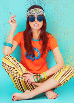 Beautiful hippy girl portrait sitting and smoking weed, dispersion effect
