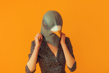 Woman portrait taking off pigeon mask