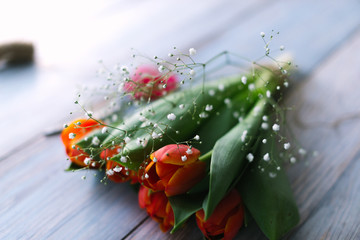 Blossoming tulips on a light wooden background. Spring background, concept