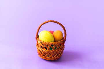 Easter eggs in a basket on a wooden background