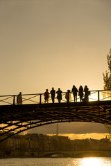 Tourists enjoy the warmth of spring, on a bridge of the Seine river in Paris.