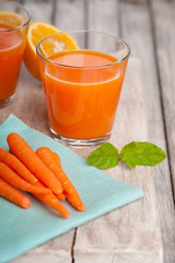 Glasses with carrot juice, sliced orange and mint leaf 