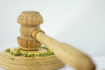 Wooden judge hammer with sound block on the white mirror background - Legality of cannabis, legal and illegal cannabis on the world.