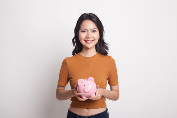 Young Asian woman with a pig coin bank.