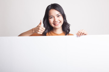 Young Asian woman show thumbs up with blank sign.