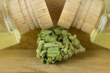 Medical Oil Cannabis - marijuana flowers on the wooden stopper with cannabis oil  bottles.