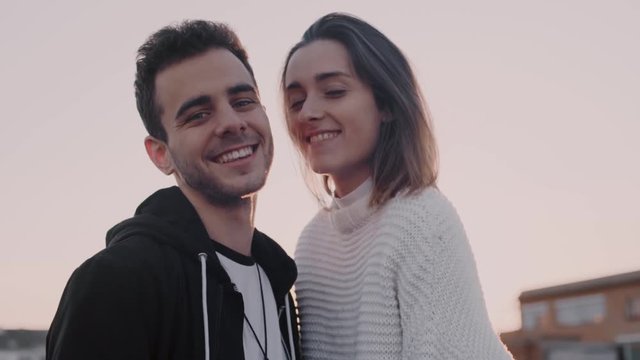 Slow motion portrait of beautiful couple of young teenagers or hipster millennials of new generation, romantic in love relationship boy and girl look in camera, smile and happy real emotions