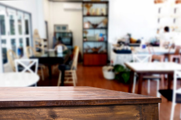 Selected focus empty brown wooden table and Coffee shop or restaurant blur background with bokeh image. for your photomontage or product display.