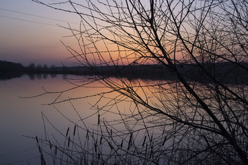 Fototapeta na wymiar Sunset landscape. Pond at sunset time. Evening color of sky.