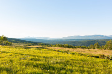 View from a meadow above a mountain landscape with beautiful light
