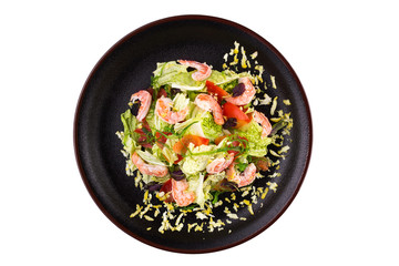 Tasty salad with prawns, vegetables and seaweed Chukka, dressed with sauce on a black plate. Salad in a plate isolated on white background. Seafood salad.