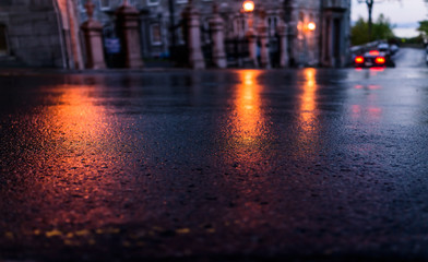 Macro closeup of wet street pavement at night with reflection of golden lantern lights background...