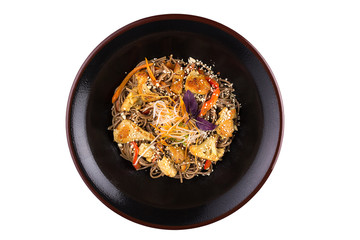 Buckwheat noodles with vegetables and mushrooms with teriyaki sauce isolated on white background. Buckwheat noodles in a black plate.