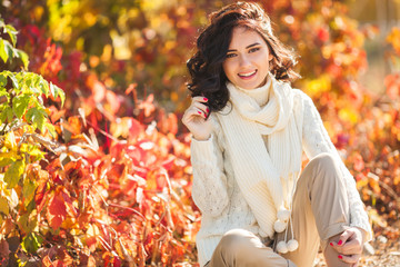 Young beautiful woman at autumn background. Portrait of attractive young girl outdoors