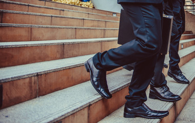 defocused or blured Businessman walking the stairs with city background, Businessmen go to success concept, vintage style.