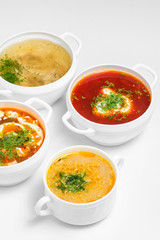 Variety of soups, restaurant hot dishes, healthy food isolated at white. Top view.