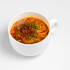 Vegetable soup served  in a white bowl on a white background