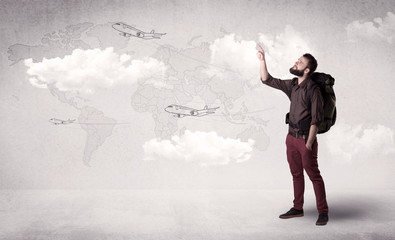 Handsome young man standing with a backpack on his back and planes in front of a world map as a background 