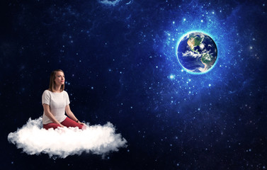 Obraz na płótnie Canvas Caucasian woman sitting on a white fluffy cloud sitting and wondering at planet earth