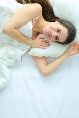 Pretty woman lying down on her bed at home