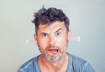 man with ear sticks on a light background care