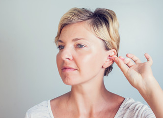 Woman cleans ears with cotton sticks isolated on white