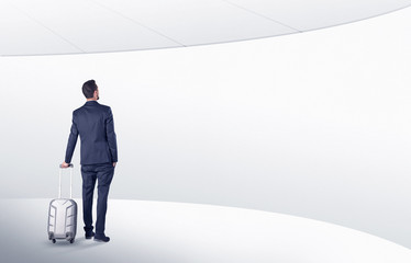 Obraz premium Businessman with back walking in a white waiting room with empty walls around 