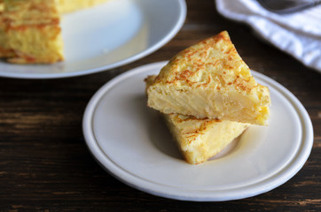 Homemade tortilla,  typical Spanish omelette made with eggs and potatoes. Traditional Spanish tapas or snack served in white plate.