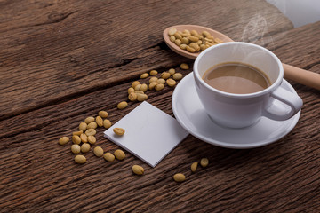 Coffee in cups and fresh coffee beans arranged on wooden floor. And there is white paper for adding text.