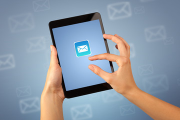 Female fingers touching tablet with mail icon on it 