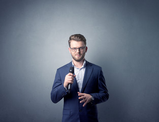 Businessman speaking into microphone with blue background