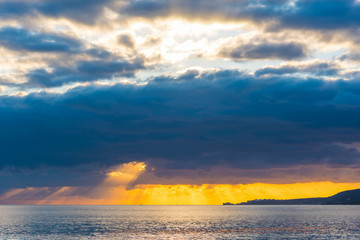 Fototapeta na wymiar Dark clouds over the sea at sunset