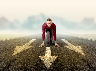 Young determined businessman kneeling before three arrows 