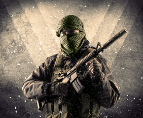 Portrait of a dangerous masked armed soldier with grungy light background 