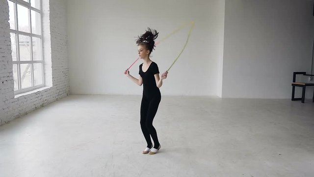 Mixed race. Skipping girl training at the gymnastics school working out is healthy fitness. Healthy teenage girl skipping with a jump rope. Sporting exercise, stretch, flexibility, aerobics