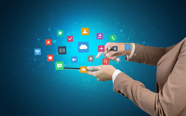 Female hand touching tablet with application icons above