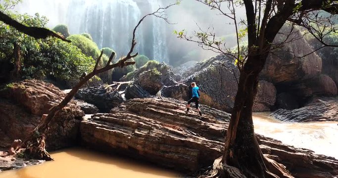 AERIAL 4K : Tourist traveller walking at Elephant Waterfall below in trip in Vietnam, woman with enjoying nature