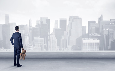 Businessman standing with his back on a roof with objects in his hand
