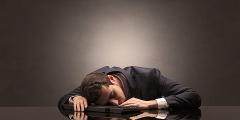 Young businessman fell asleep at his workplace with copy space