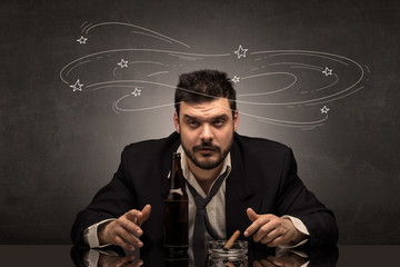 Young drunk man at his office with doodles around
