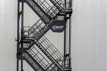 industrial multi-section ladder near the white wall of the factory