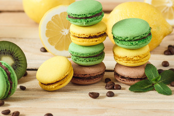 Green, yellow and brown french macarons with kiwi coffee beans and mint decorations