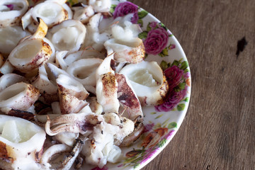 Top view of octopus grill include egg cut into pieces for eat of seafood. The dish is placed on the table.